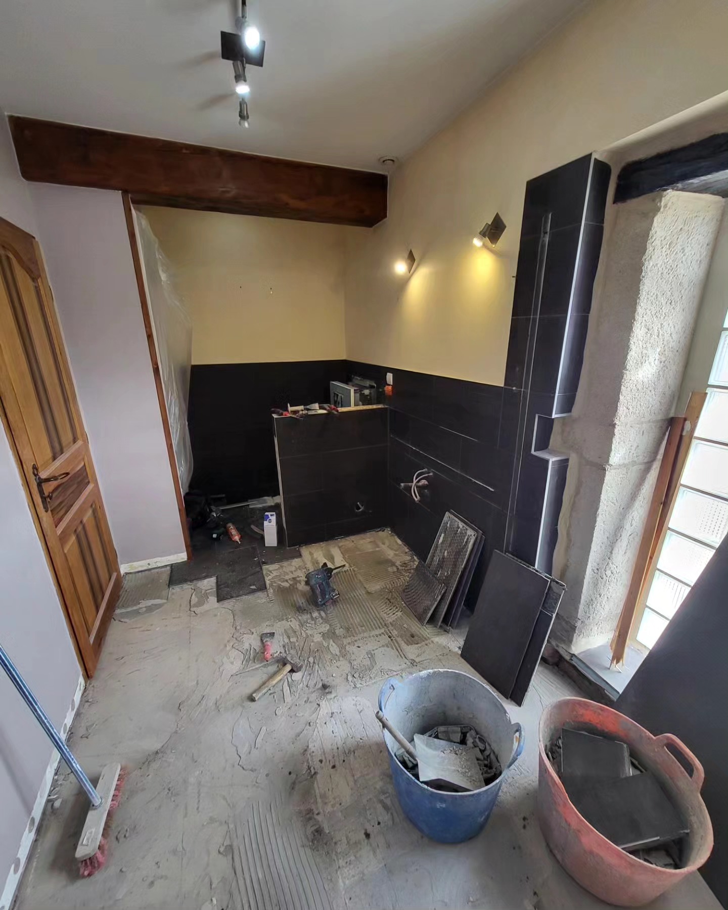 Rénovation d'une salle de bain à Savigneux. Douche à l'italienne et mur avec un carrelage imitation parquet